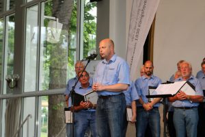 Vorsitzender Manfred Speuser begrüßte das Publikum in der Konzerthalle und stellte den Chor aus Bedburg-Königshoven vor.