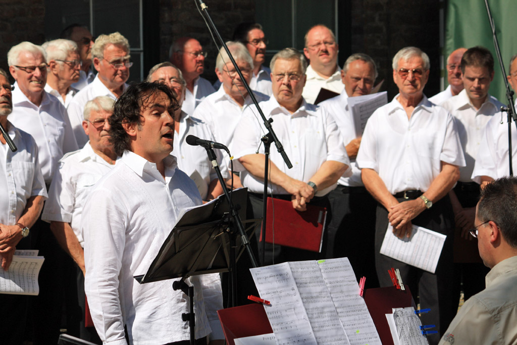 Tenor Donald Cullen unterstützte die Chorgemeinschaft mit seinen Soloparts und konnte das Publikum im Paffendorfer Schlosshof begeistern. [Foto: Bastian Schlößer]